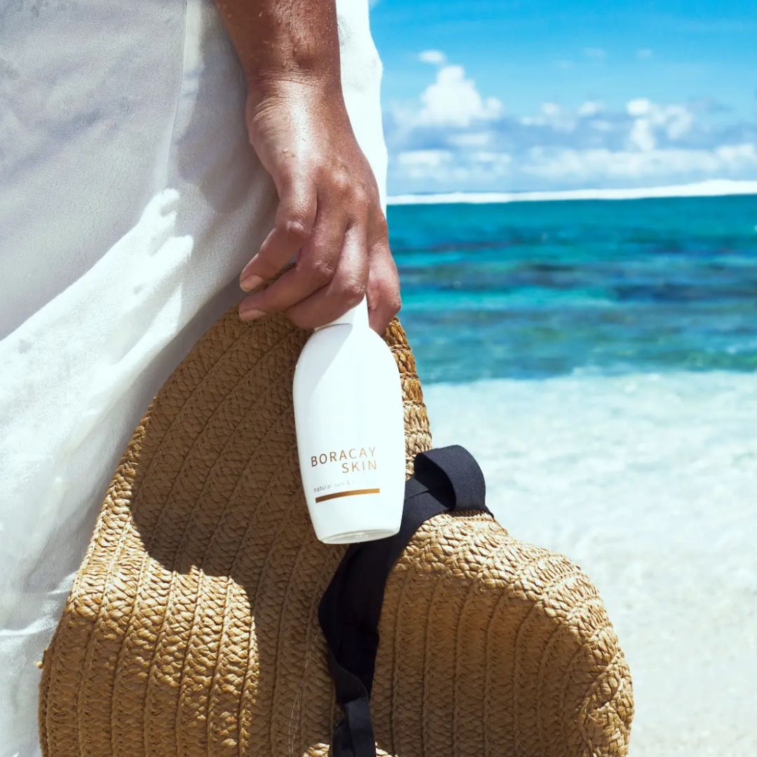 Boracay Skin Natural Sun and Body Oil held by the beach